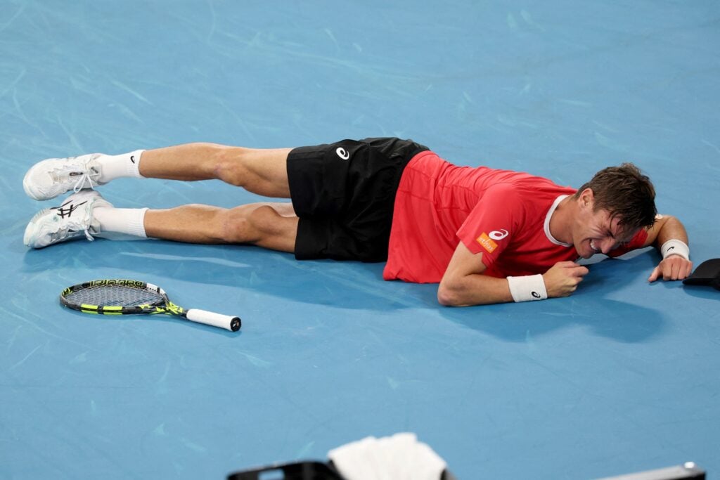 Raphael Collignon suffers from cramps against Alex de Minaur