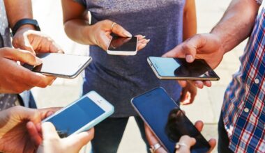 5 friends with smartphones, close up.