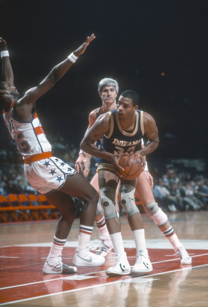 Clark Kellogg attempts to shoot the ball while defenders surround him