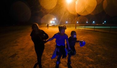 Young migrants hold hands as they run in the rain at an intake area after turning themselves in upon crossing the U.S.-Mexico border in Roma, Texas, May 11, 2021. (AP Photo/Gregory Bull)