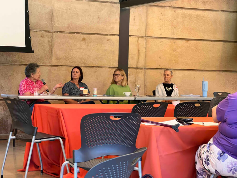 Expert panelists sit behind a table addressing questions during the fourth anniversary event.