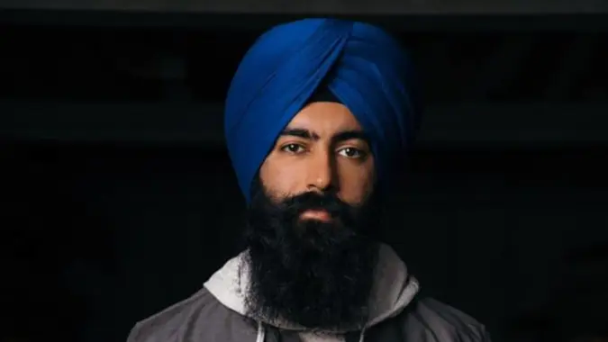 Jaspreet Singh looking into the camera with a serious expression, on a black background.