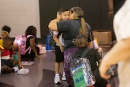 Kindergarten student Jayren Contreras, 5, receives a kiss from mom Cesia Cruz as he fears...