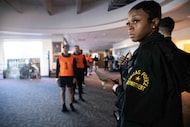 Dallas Police Officer Delnesha’ Bryant holds a clipboard as potential recruits prepare to do...