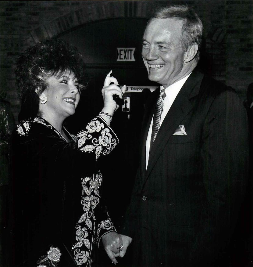 Elizabeth Taylor sprays some of her new men's cologne called "Passion" on Dallas Cowboys...