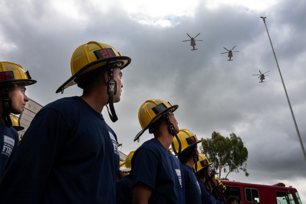 Firefighters look on as the LAFD performs a missing-man formation...