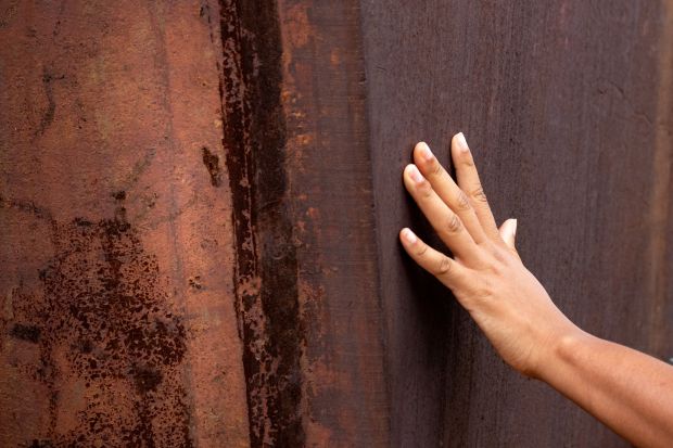 A visitor reaches out to touch a section of the...