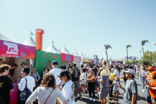 People line up at the food stands at a previous...