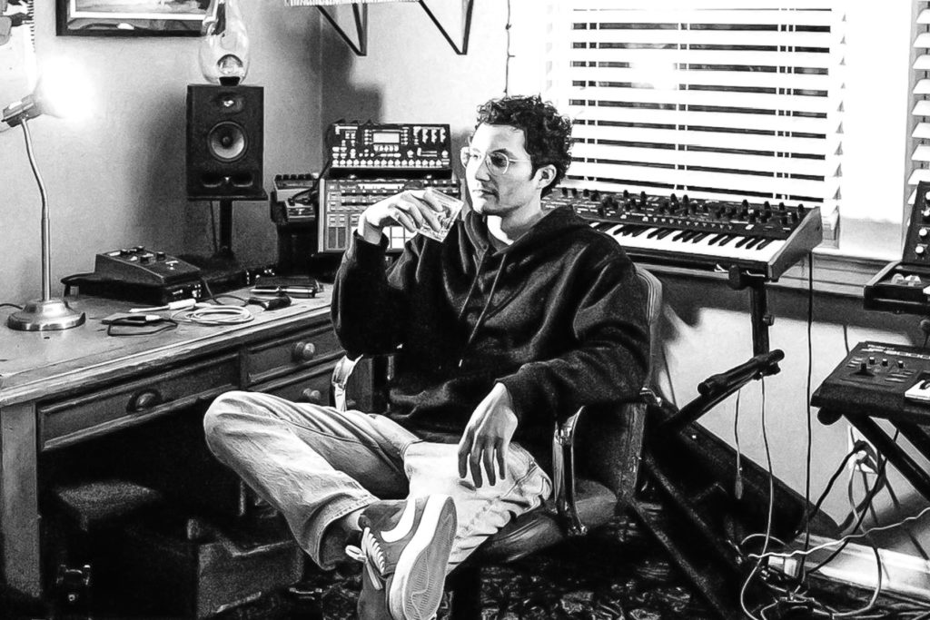 Jonah Pierre in his home-studio with keyboards, synthesizers, and recording equipment.