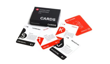 A set of playing cards with a black box labeled "CARDS." The cards are spread out, featuring minimalist designs with categories like Landscape, Street, Classic, and Monochrome in black, white, and red colors.