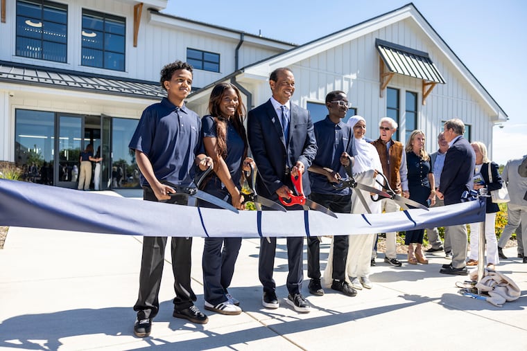 Tiger Woods poses with some TGR Learning Lab students at the grand opening of the Cobbs Creek center that his foundation helped fund.