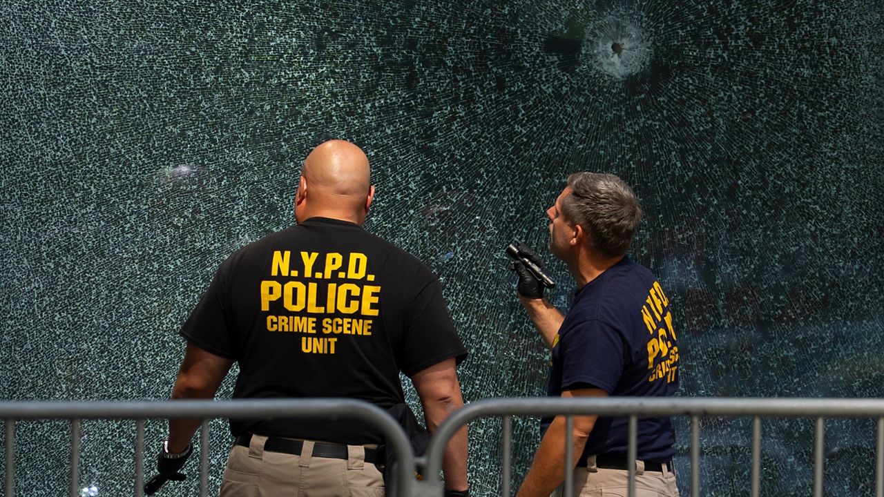 Members of the NYPD's Crime Scene Unit examine a door with bullet holes on Tuesday, July 29, 2025, in New York, the day after the deadly shooting. (AP Photo/Yuki Iwamura, File)