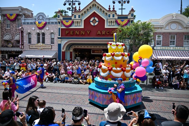 A giant birthday cake makes its way down Main Street,...