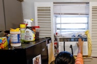 Guadalupe Arista points to the window AC unit that sits in the kitchen window of her...