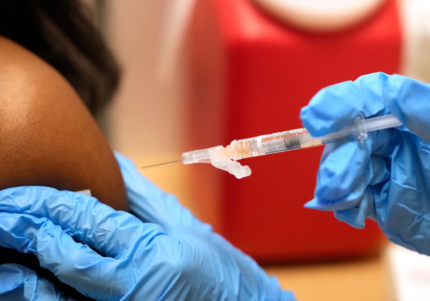 Pharmacist Kim Nguyen administers a Moderna Spikevax COVID-19 vaccine at a CVS.