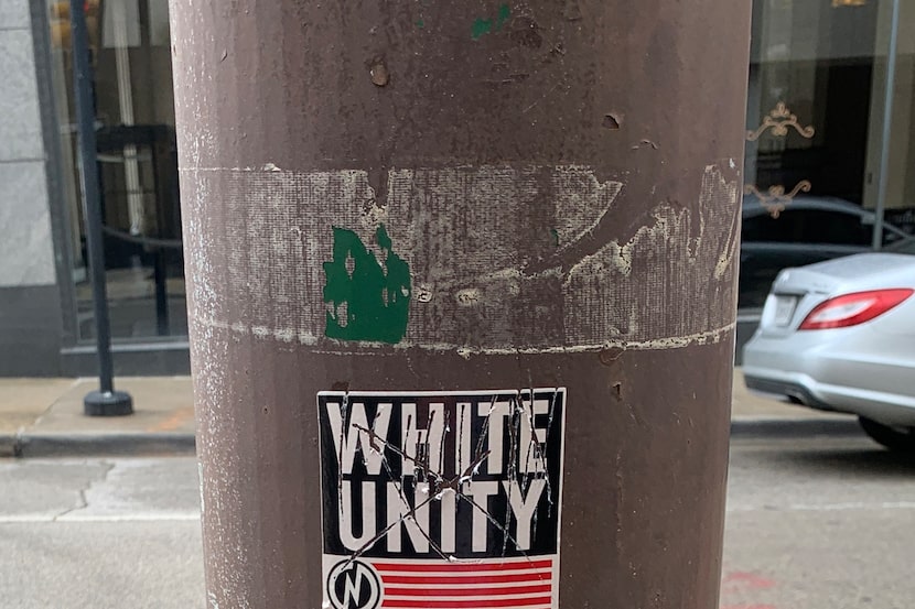 A white-nationalist sticker affixed to a traffic-light pole near Harwood and Jackson streets...