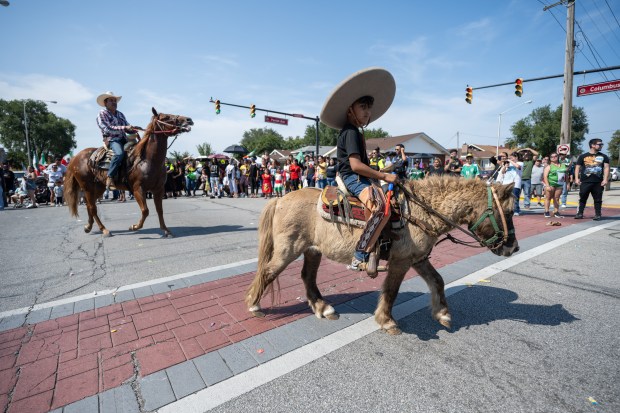 Parade participants ride ponies and horses past paradegoers during the Fiestas Patrias Parade in East Chicago on Sunday, Sept. 15, 2024. (Kyle Telechan/for the Post-Tribune)