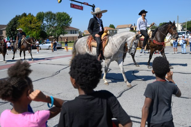 Parade participants ride horses as onlookers wave during the 101st annual Fiestas Patrias parade on Sunday, Sept. 14, 2025. (Kyle Telechan/for the Post-Tribune)