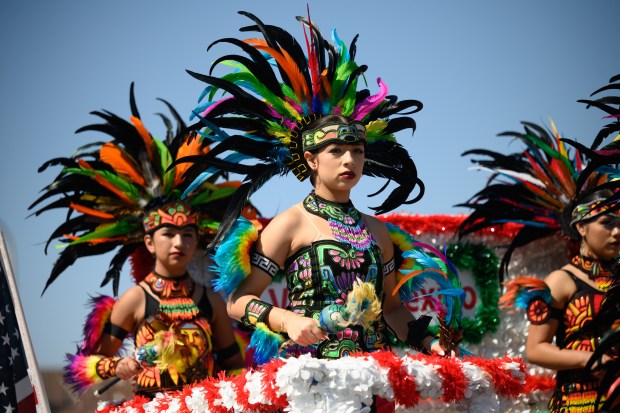 Ballet Folklorico Yolotzin members, donning stylized Trajes de Concheros, perform on a float during the 101st annual Fiestas Patrias parade on Sunday, Sept. 14, 2025. (Kyle Telechan/for the Post-Tribune)