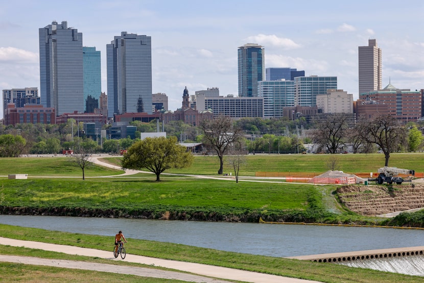 A cyclist rides on a trail along the Trinity River near downtown Fort Worth, Wednesday,...
