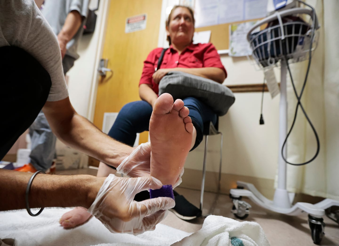 After a foot soak, foot clinic manager Sajen Plevyak smooths the feet of Emilia Elizabeth Figueroa at St. Francis House on Tuesday, July 22. AmeriCorps members, working with the Boston Health Care for the Homeless Program, give foot soaks and foot exams to homeless patients.
