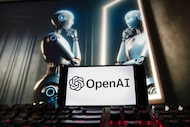 FILE - The OpenAI logo is displayed on a cellphone with an image on a computer monitor...