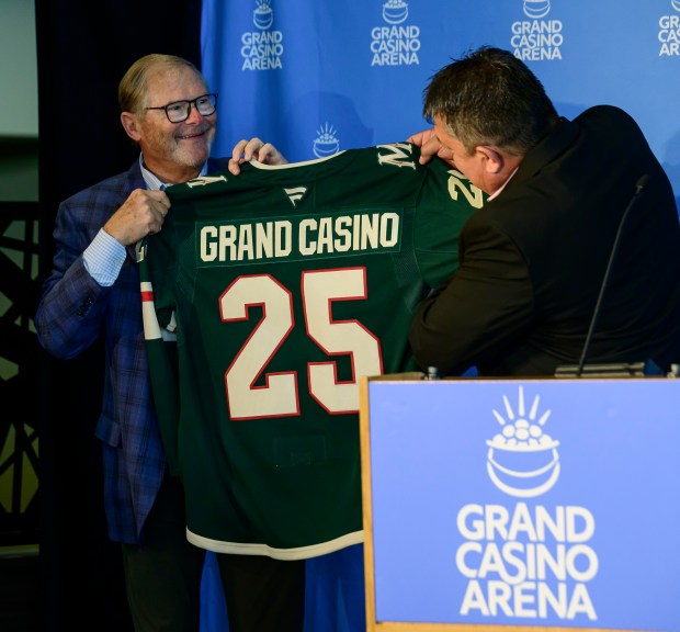 Virgil Wind, the chief executive of the Mille Lacs Band of Ojibwe, right, looks over a Minnesota Wild jersey presented to him by Wild owner Craig Leipold.