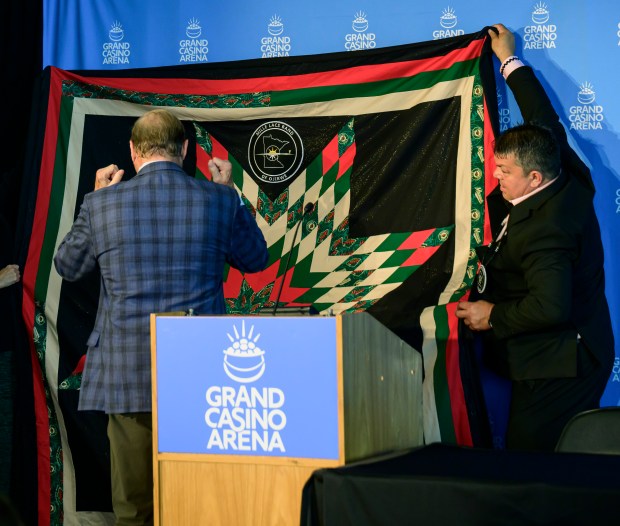Virgil Wind, chief executive of the Mille Lacs Band of Ojibwe, right, and representatives of the Mille Lacs Band of Ojibwe present Minnesota Wild owner Craig Leipold, center, with a Minnesota Wild-themed blanket.
