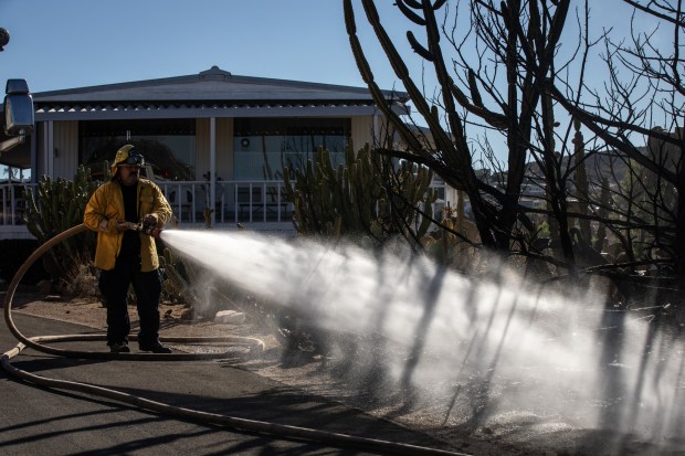 Crews work to put out a fire at Monterey Mobile Lodge Monday in Lakeside. (Ana Ramirez / The San Diego Union-Tribune)
