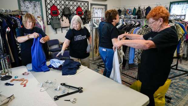 Volunteers in the closet sort clothing items at the Good Shepherd Ministry Center in El Cajon. (Alejandro Tamayo / The San Diego Union-Tribune)