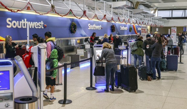 People check their bags and prepare to fly with Southwest Airlines at San Diego International Airport on Friday, Dec. 30, 2022 in San Diego, CA. Southwest Airlines had to cancel flights nation wide over the last week. (Eduardo Contreras / The San Diego Union-Tribune)