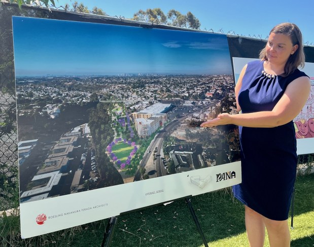 Rachel Lozano Castro of the Partnership for the Advancement of New Americans (PANA) stands in front of a rendering of the Global Village Refugee and Immigrant Cultural Hub, a development that received $100,000 in the 2025 Community Clean Energy Grants. (Rob Nikolewski/The San Diego Union-Tribune)