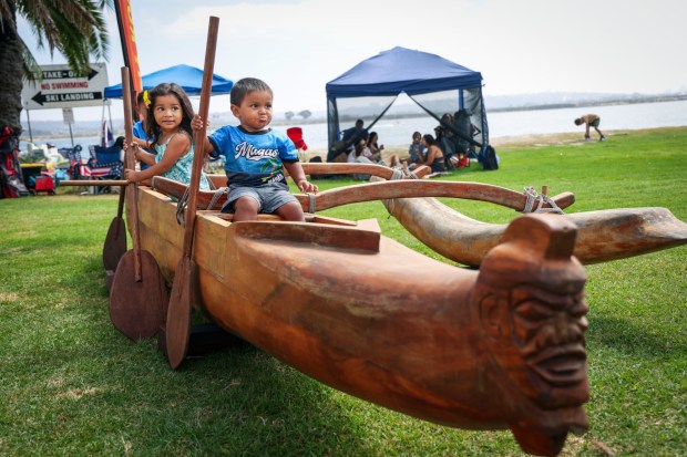 Fabian Laniyo,1, poses for a photo on a Hawaiian canoe atvthe Pacific Islander Festival at Ski Beach on Mission Bay on Saturday, Sept. 2025. The festival featrured foodbooths, atras and craftes booths and performers form several Pacific Island Nations. ( Photo by Sandy Huffaker for The San Diego Union-Tribune)