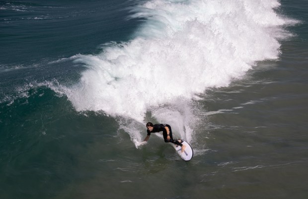 A man surfs near the Oceanside Pier on Tuesday, June...
