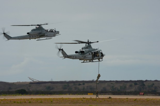 Demonstration of the Marine Air Ground Task Force (MAGTF), as Marines fast rope to the ground with support from a nearby AH-1Z Viper helicopter. The event which includes aerial vintage aircraft, displays and immersive experiences runs through Sunday. (Nelvin C. Cepeda / The San Diego Union-Tribune)