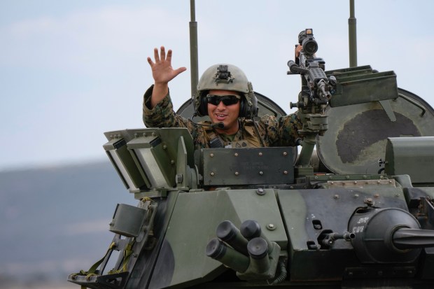 Following the demonstration of the Marine Air Ground Task Force (MAGTF), Marines drive their combat vehicles down the fight waving at the audience. The event which includes aerial vintage aircraft, displays and immersive experiences runs through Sunday. (Nelvin C. Cepeda / The San Diego Union-Tribune)