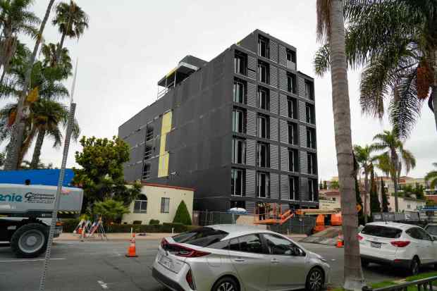 Factory-built housing like this apartment building on 4th Avenue in Hillcrest is quicker to install, meaning neighborhoods with new housing projects only get disrupted for about six weeks, instead of more than a year. But installation, which often involves cranes, can be notably disruptive and typically requires street closures. (Alejandro Tamayo / The San Diego Union-Tribune)