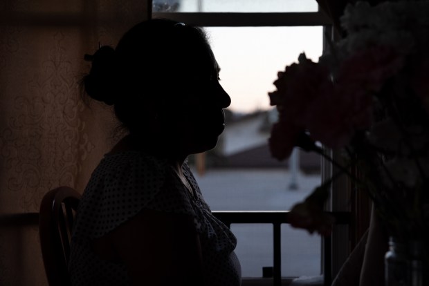 Etelvina poses for a portrait inside the home she shares with one of her children on Tuesday, Aug. 26, 2025 in Encinitas, CA. Etelvina's voice cracks and tears begin to form as she talks about how her husband was deported back to Mexico in mid-July. She has lived and worked in the United States for more than 20 years. (Ana Ramirez / The San Diego Union-Tribune)