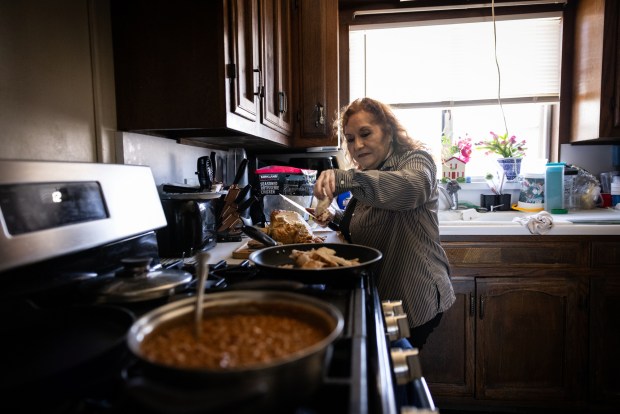 Marina Avila makes lunch for her family after church on Sunday, Aug. 24, 2025 in San Diego, CA. Marina Avila talks about her husband's favorite food and how she misses him. Victor Varela Avila, 69, was detained after returning with his wife from visiting their son in Japan. He has been jailed at the McFarland ICE detention center since May because of a misdemeanor from 16 years ago. ....The family shared stories about Avila. How he likes to sing karaoke, box in the back yard and how he has a favorite chair he sits in. (Ana Ramirez / The San Diego Union-Tribune)