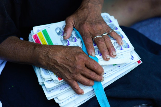 Cristina Jaimez, 60, collects her medication in her tent at an encampment nearby a freeway off-ramp in the Sherman Heights community. (Nelvin C. Cepeda / The San Diego Union-Tribune)