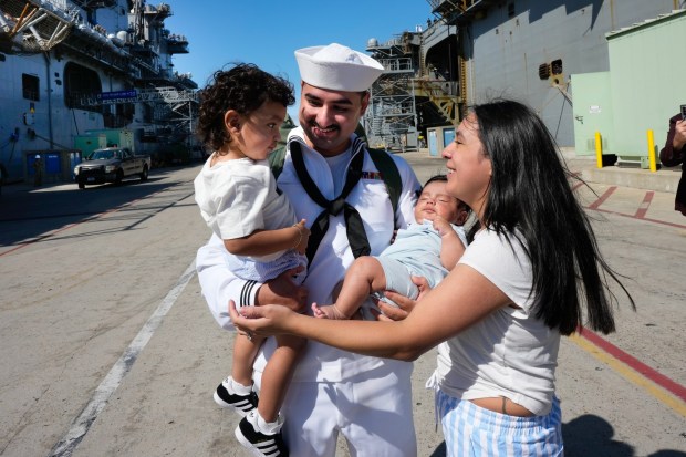 On Thursday, Sept. 25, 2025, the USS America (LHA 6) pulls into Naval Base San Diego, and Ashley Gonzalez passes their two sons and her husband, Isaac Gonzalez, who is returning to San Diego from Japan. After serving in Japan as her homeport for the past six years, the USS America will now be based in San Diego.   (Nelvin C. Cepeda / The San Diego Union-Tribune)