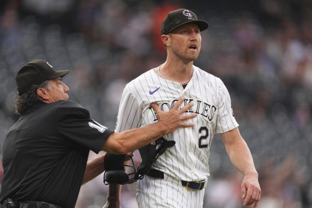 Home plate umpire Phil Cuzzi, left, holds back Colorado Rockies starting pitcher Kyle Freeland as he yells at San Francisco Giants' Rafael Devers after his two-run home run in the first inning of a baseball game Tuesday, Sept. 2, 2025, in Denver. (AP Photo/David Zalubowski)