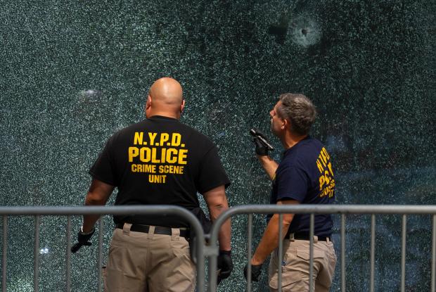 Members of the NYPD's Crime Scene Unit examine a door with bullet holes, Tuesday, July 29, 2025, in New York, the day after a deadly shooting. (AP Photo/Yuki Iwamura)
