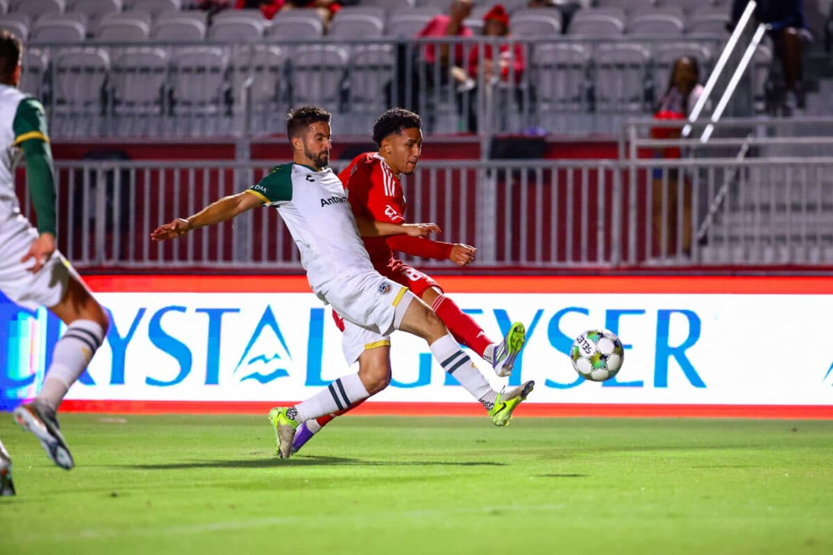 Alameda Post - an Oakland Roots player goes for the ball in a match against Phoenix Rising FC