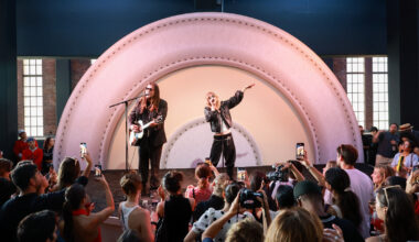 Two people stand on a stage, one sings while the other plays guitar and sings. Behind them is a Target logo.