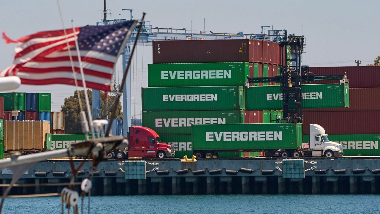 Shipping containers sit stacked at the Evergreen terminal at the port of Los Angeles, Friday, Aug. 1, 2025. (AP Photo/Damian Dovarganes)