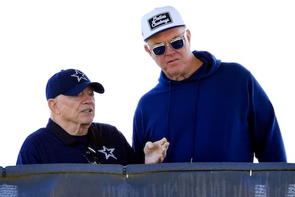 Dallas Cowboys owner Jerry Jones (left) visits with his son Stephen Jones in their training...