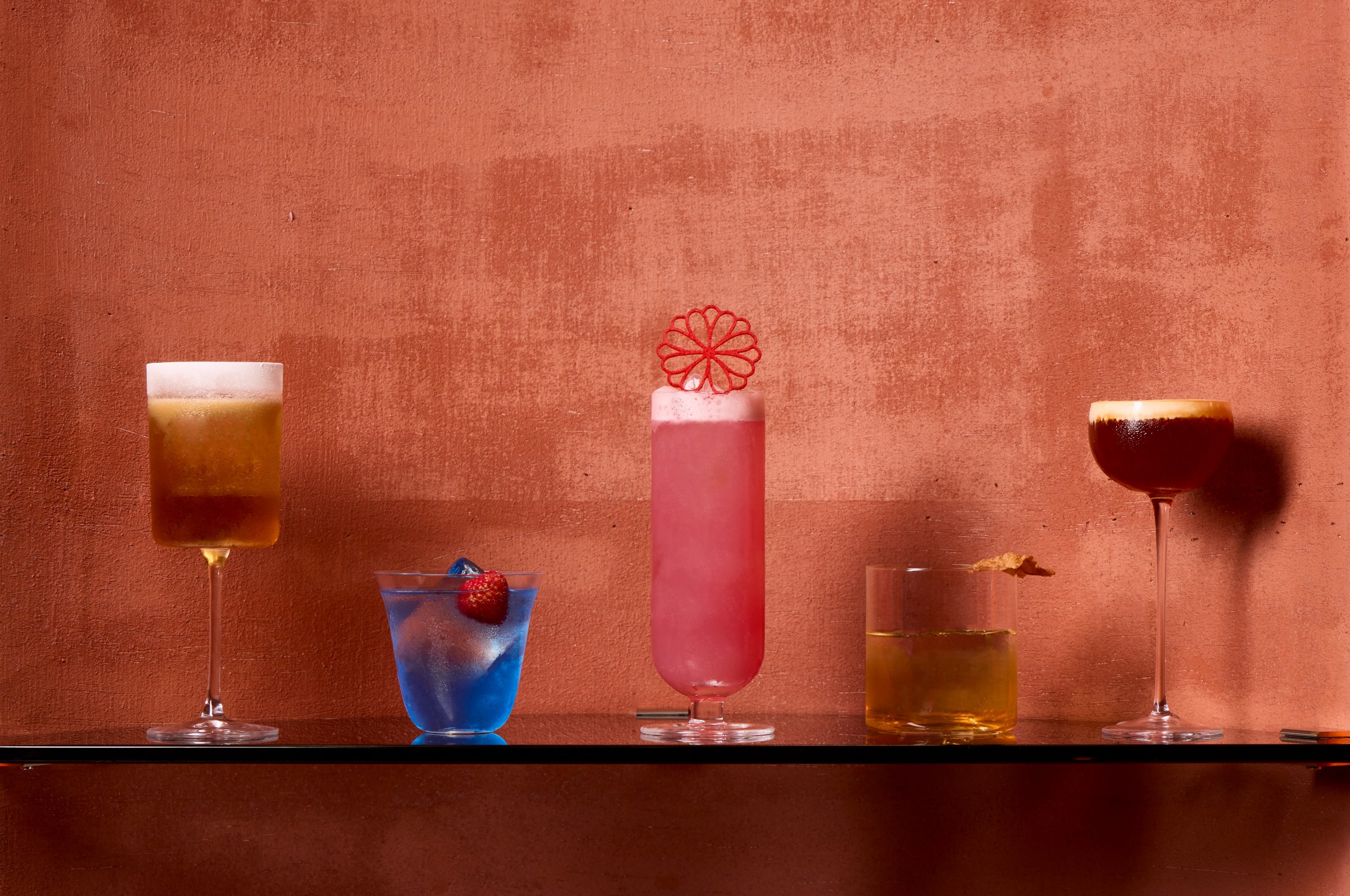 A table of five colorful cocktails.