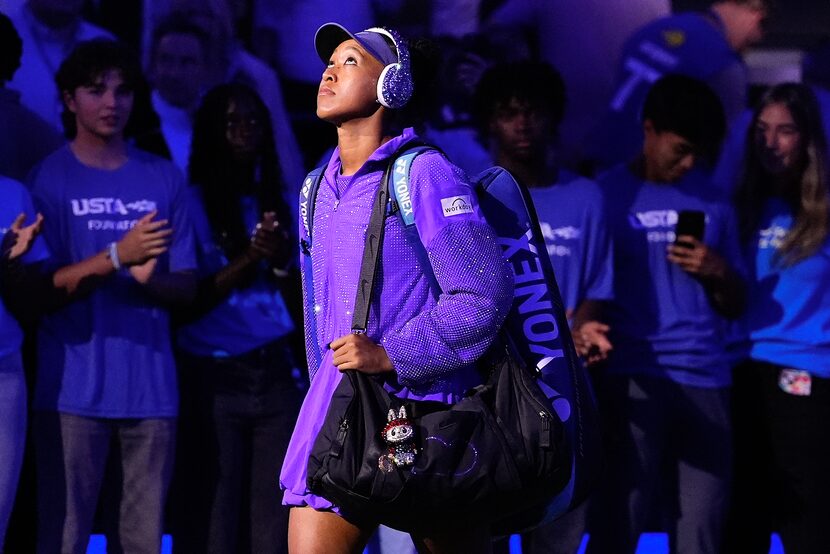 Naomi Osaka, of Japan, walks on the court with a Labubu doll hanging from her bag before...