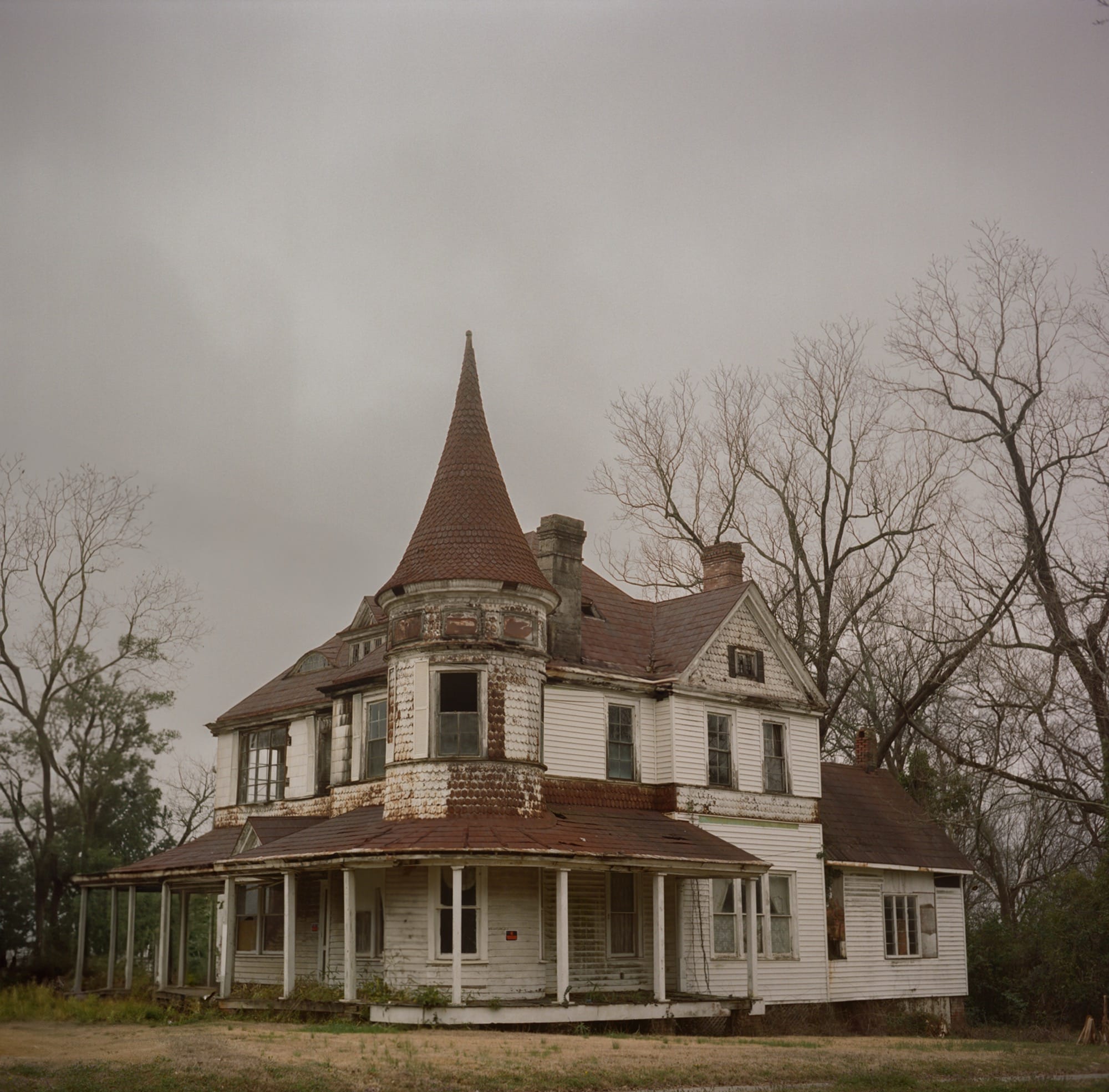 a photo of an abandoned, turreted house by Bryan Sansivero